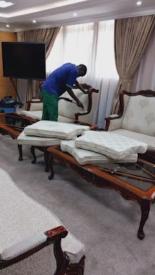 Technician cleaning upholstered chairs in a living room